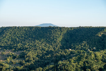 Exterior shot of beautiful mountain gorge with green forest with blue sky in background