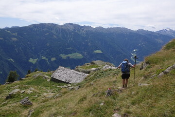 Fototapeta na wymiar Wanderer an einer Almhuette bei Giggelberg im Vinschgau