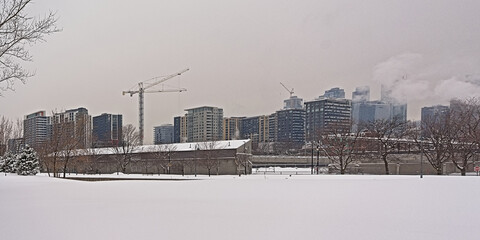 Cityscape with skyscrapers of Montreal, view from a snow covered field across Saint Lawrence river
