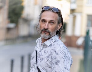 Portrait of man in city. male is walking by downtown. Bearded happy man on urban blured background