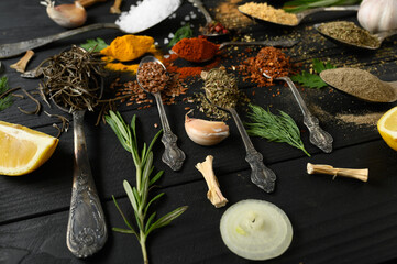 Colorful various herbs and spices for cooking on dark wooden rustic background