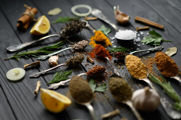 Colorful various herbs and spices for cooking on dark wooden rustic background
