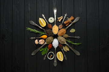 Colorful various herbs and spices for cooking on dark wooden rustic background