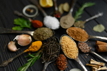 Colorful various herbs and spices for cooking on dark wooden rustic background
