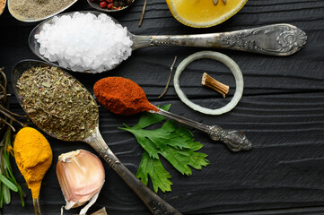 Colorful various herbs and spices for cooking on dark wooden rustic background