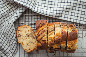 Fresh banana bread on the white background. Homemade pastry on the checkered cloth. Flat lay
