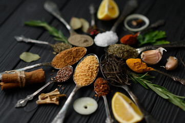 Colorful various herbs and spices for cooking on dark wooden rustic background