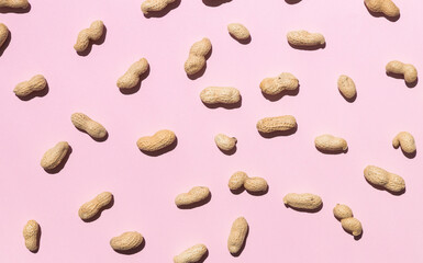 Tasty peanuts on pink background, top view