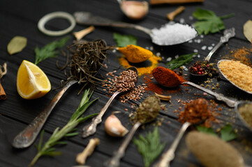 Colorful various herbs and spices for cooking on dark wooden rustic background