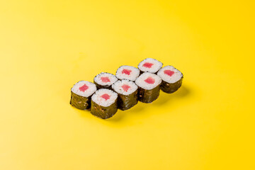 roll tuna maki with rice on yellow background © Алиса Королевская