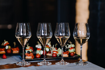  Champagne glasses on the background of snacks on the table