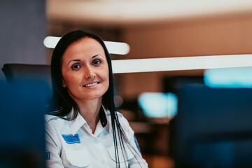 Female security operator working in a data system control room offices Technical Operator Working...
