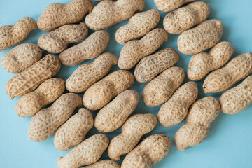 Fototapeta na wymiar Shelled peanuts on blue background
