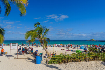 People on the sandy beach with cocos palms in Playa del Carmen, Yukatan, Mexico