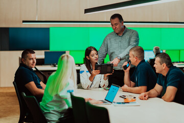 Group of security guards sitting and having briefing In the system control room They're working in security data center surrounded by multiple Screens