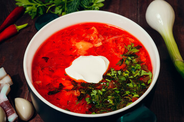 Borsch is a traditional Ukrainian Russian hot soup. Beets, cabbage, carrots, potatoes, peppers, onions, dill, parsley, in meat broth, with white sour cream. Served with chili, garlic, onion, bacon