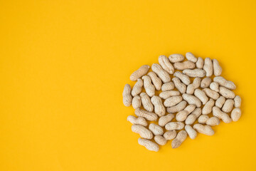 Shelled peanuts on yellow background