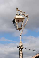 Fototapeta na wymiar Old Vintage Cast Iron Lantern on Post against Cloudy Blue Sky 