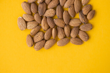 Almonds isolated on yellow background