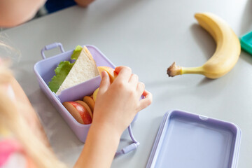 School lunch box with healthy food. Child eating in cafeteria. Happy kid have vegetarian breakfast...