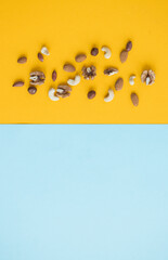 nuts mix for a healthy diet cashew, peanut, hazelnuts, walnuts, almonds on yellow background