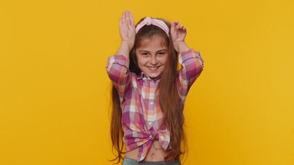 I am little bunny rabbit. Lovely funny young preteen child girl kid smiling friendly and doing bunny ears gesture on head, having fun, fooling with humorous comical mood. Little cute toddler children