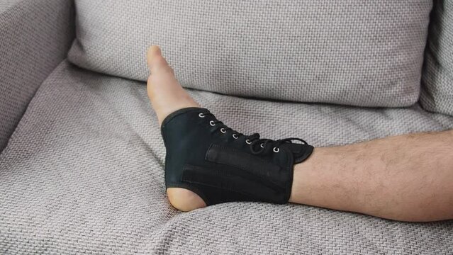 Compression ankle stabilizer bandage. Leg injury and sprain of young sports man