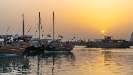 Fototapeta premium Doha, Qatar- Multiple wooden fishing dhows docked in the doha corniche.