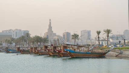 Obraz premium Doha, Qatar- Multiple wooden fishing dhows docked in the doha corniche.