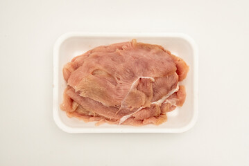 Package of fresh chicken breast fillets in a white styrofoam tray