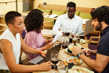 The colleagues at the dinner table in the restaurant sit and have a business meeting and brainstorm.