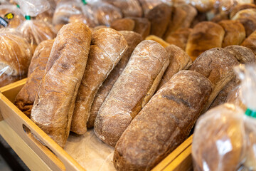 A variety of bread products with sesame: buns, pretzels, poppy seed buns for sale in a bakery