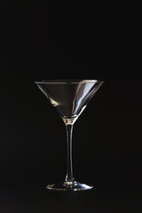 Martini cosmopolitan cocktail glass set against a black background. Drinks glass with copy space