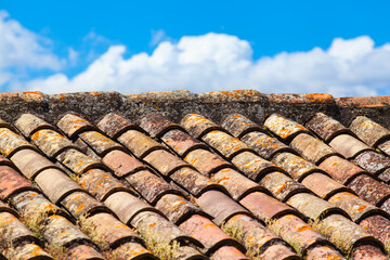 Old Mediterranean Tile Roof / Tiles of weathered red roof under Provence sky