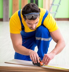 Professional contractor laying flooring at home