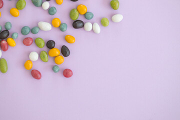 Top view of colorful sweets on violet background with copy space.