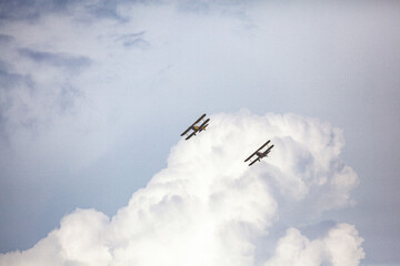 Biplanes flying in storm clouds over San Diego, California. © DAVID