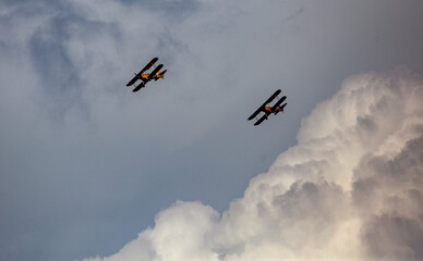 Biplanes flying in storm clouds over San Diego, California.