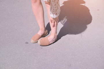 legs of a woman with a twisted ankle while walking on the street close-up