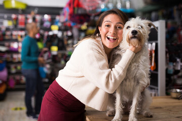 Portrait of happy woman with beloved dog in pet shop