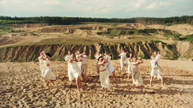 4k slow-mo drone Group of woman in white clothes dancing in a beautiful nautre landscape. ethic rural cinematic consept. Amazon dance in crater and hill.