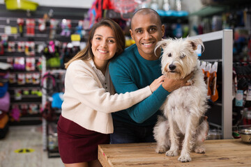 Portrait of smiling man and woman with dog shopping together in pet shop