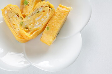 Japanese food, green onion in fried egg roll on white dish for comfort food image