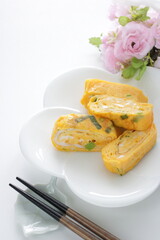 Japanese food, green onion in fried egg roll on white dish for comfort food image
