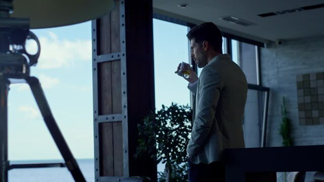 Businessman drinking whiskey in hotel lounge. Successful man vacation concept