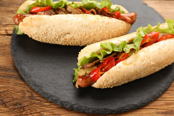 Tasty hot dogs on wooden table, closeup. Fast food
