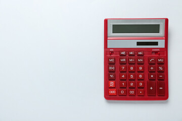 Red calculator on light background, top view. Space for text