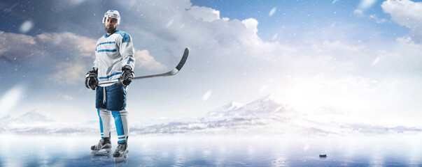 Professional ice hockey player in the mountains. Hockey player in a helmet and gloves and a stick...