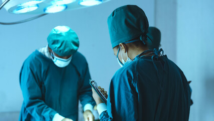 Surgery team operating in a surgical room. Doctor and nurse discuss planning surgery