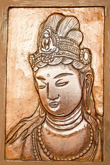 A pretty hand-carved mother Buddha shot top down. 